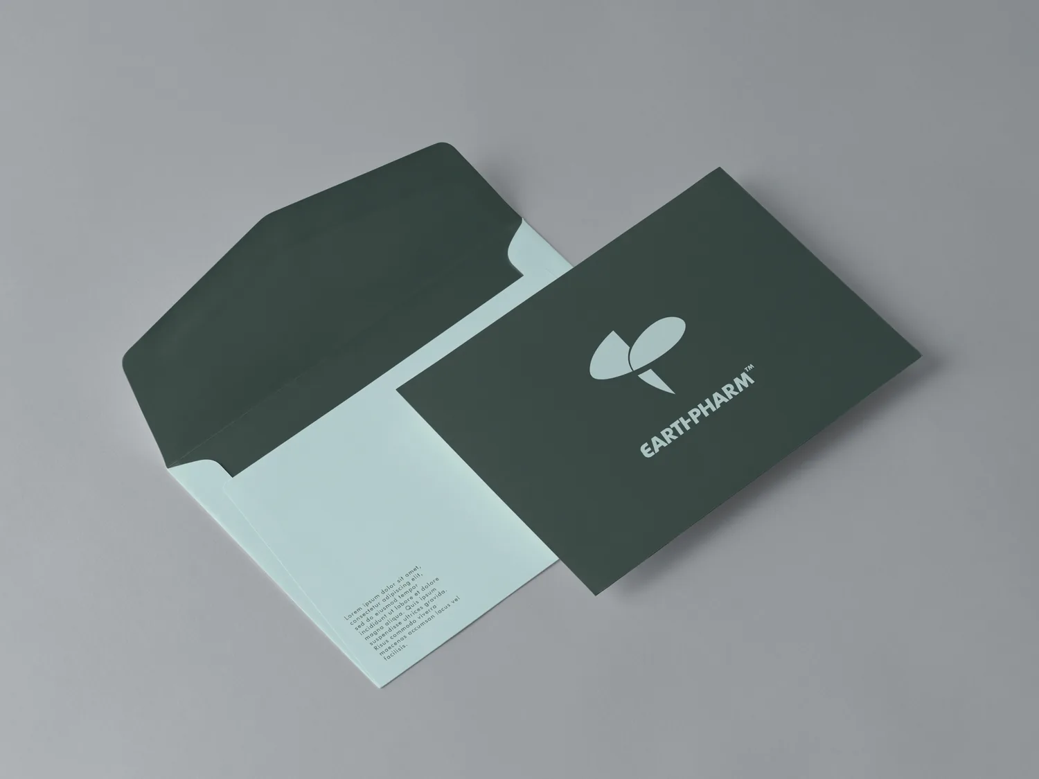 Envelopes and a card in deep green and soft aqua, as designed